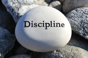 Positive reinforcement word Discipline engrained in a rock